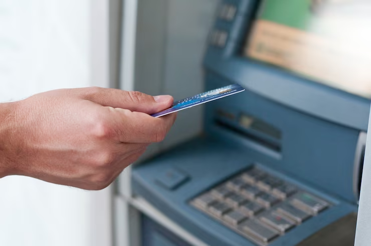 a person inserting card into an ATM