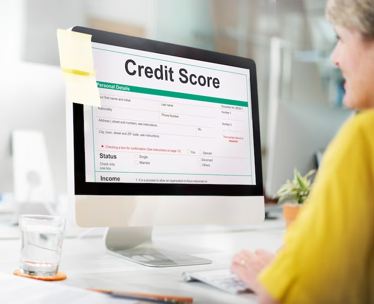a woman smile while looking at a screen which shows credit score
