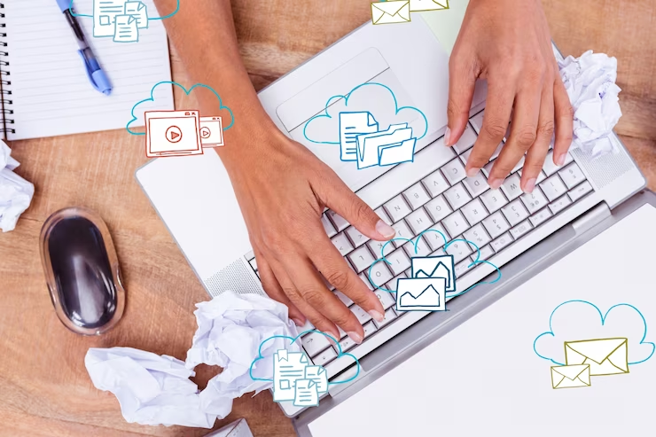 small icons of paper, emails behind clouds shown on keyboard with human hands